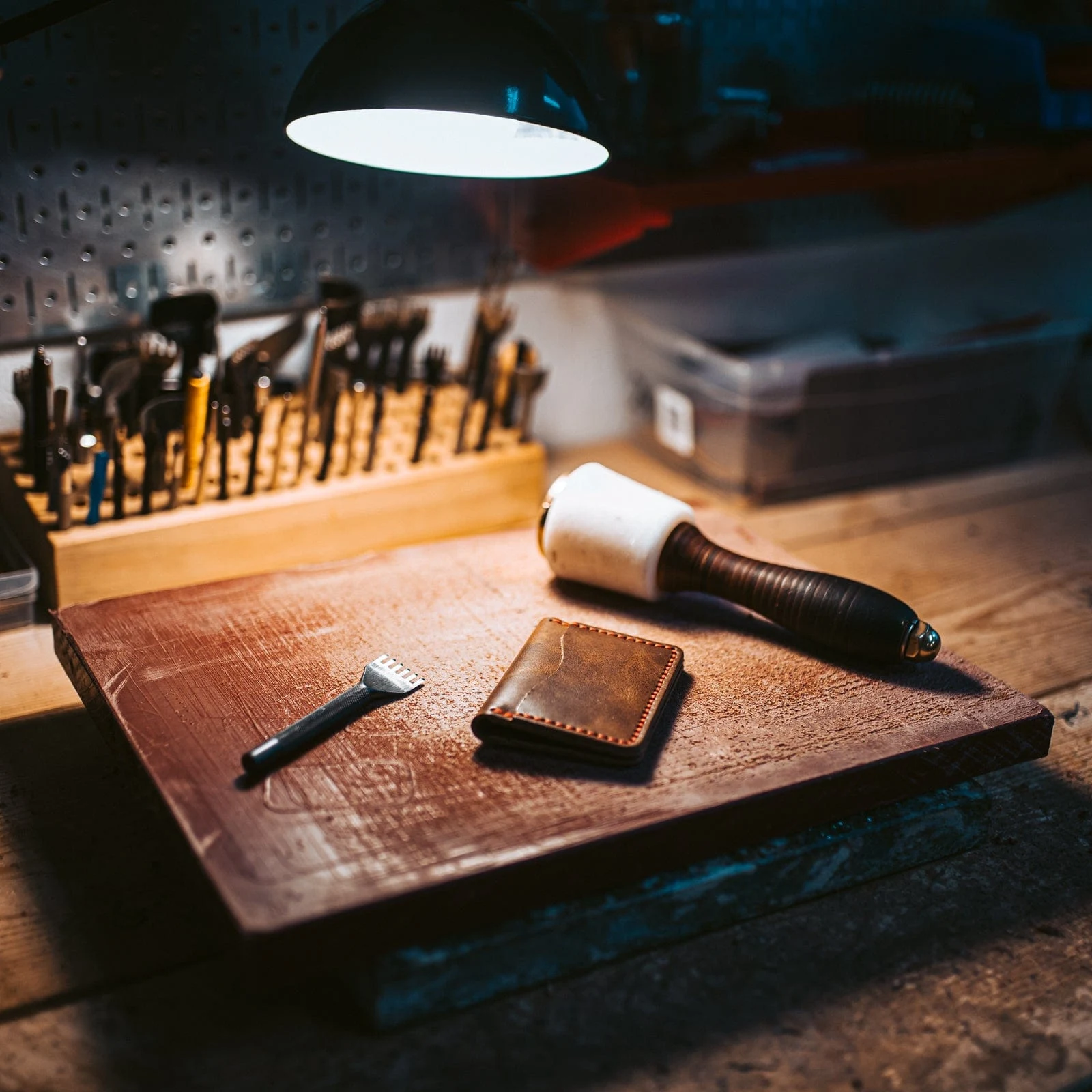 Hand tools and a finished wallet on the workshop bench