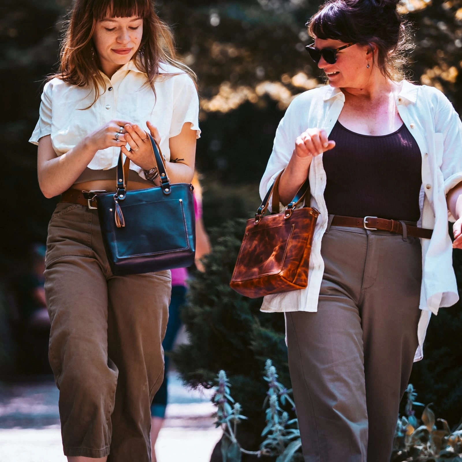 Two customers carrying Popov Leather crossbody bags